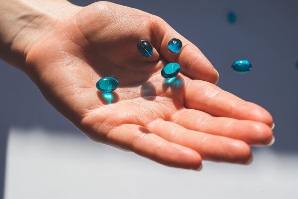 hand with blue capsule